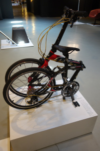 A commuter bicycle folded up so that the two wheels are placed next to each other.